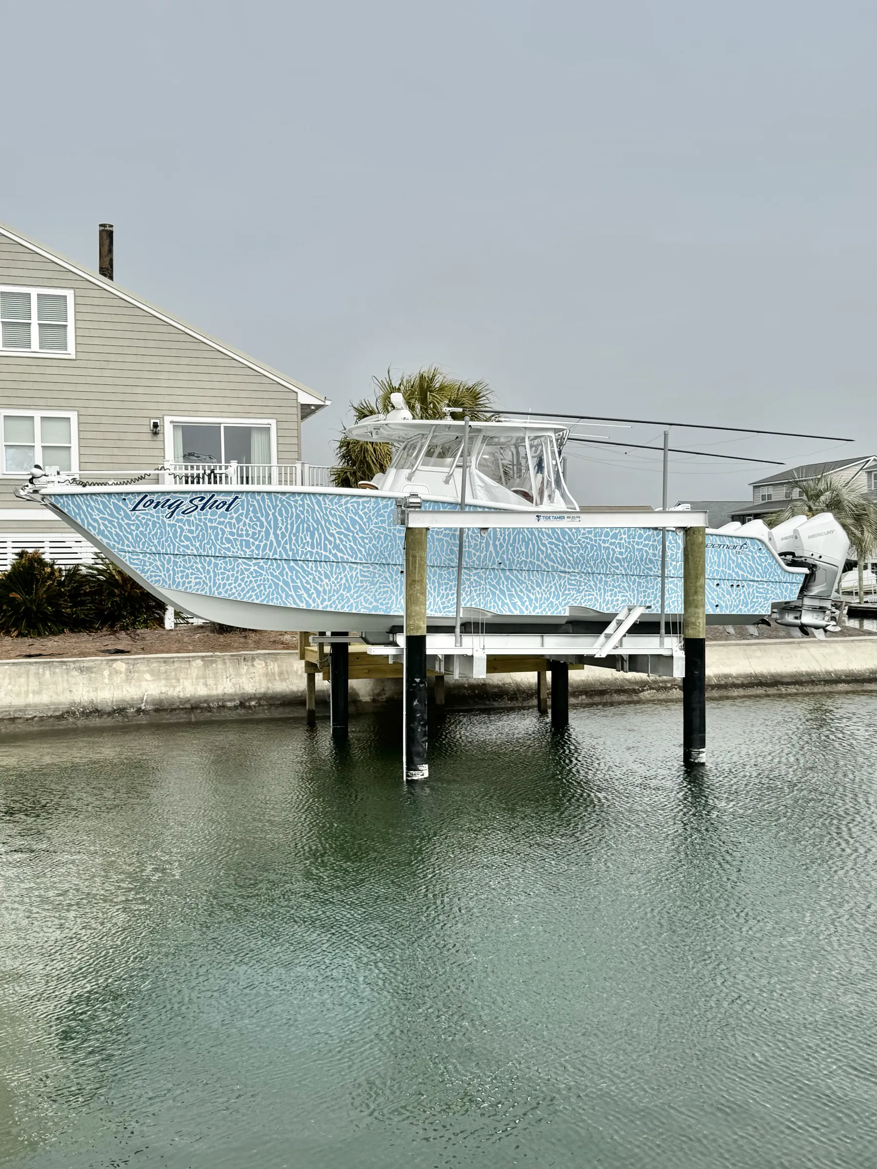 A boat on a lift beside a well-kept waterfront dock